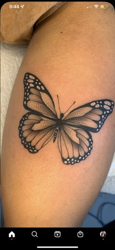 a black and white butterfly tattoo on the right thigh, it looks like an insect