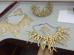 gold jewelry is displayed on a table next to a pen and notepad with writing