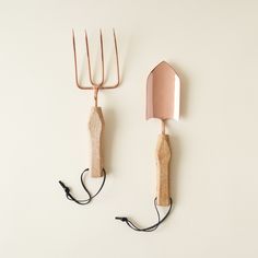 two garden utensils, one pink and the other brown