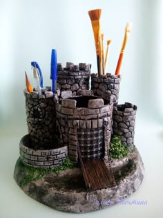 there is a miniature castle made out of rocks and stones with toothbrushes in it