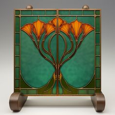 an art nouveau stained glass panel with orange flowers on green and brown background, set against a white backdrop