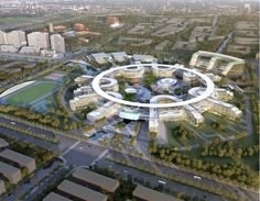 an aerial view of a circular building in the middle of a city with lots of trees and buildings around it