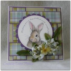 a close up of a card with flowers and a rabbit on it's side