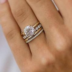 a woman's hand with two different rings on her fingers and one has an engagement ring