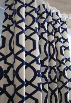 the curtain is hanging in front of a window with blue and white designs on it