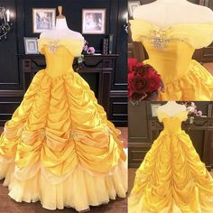 the dress is yellow and has white trimmings on it, along with flowers