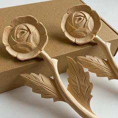 two wooden roses sitting on top of a cardboard box