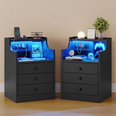 two black chests with blue lights on top of each drawer and a plant in the middle