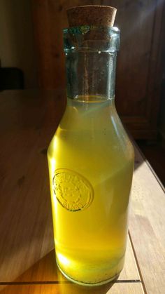 a glass bottle filled with liquid sitting on top of a wooden table