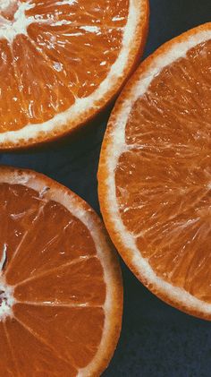 three oranges cut in half on a table