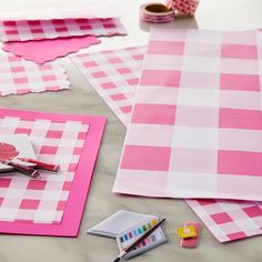 pink and white checkered paper laid out on a table with markers, washi tape, scissors and other crafting supplies