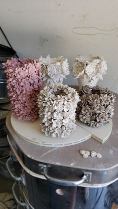 three vases with flowers sitting on top of a table