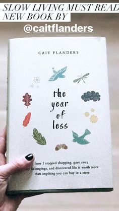 a person holding up a book with the title cat flanders's new book, the year of less