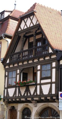 an old building with flowers on the balcony