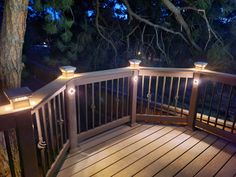 a deck with lights on it and trees in the background