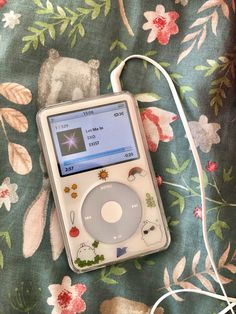 an ipod sitting on top of a floral blanket