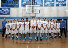 a group of young men standing on top of a basketball court next to each other