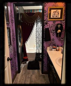 the bathroom is decorated in purple and black with an elaborate shower curtain over the bathtub