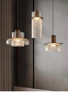 three glass pendant lights hanging from the ceiling