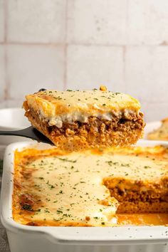 a piece of lasagna being lifted from a casserole dish