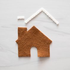 a house made out of felt sitting on top of a white table next to a toothbrush