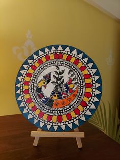 a colorful plate sitting on top of a wooden stand