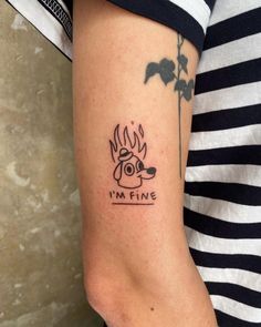 a woman with a tattoo on her arm that reads i'm fine and has a dog in flames