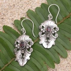 Elaborate and elegant Giri Tasmana's dangle earrings are perfect for a fancy dinner party. The Balinese artisan uses sterling silver to hand craft the floral motif centering each earring with a faceted garnet stone for an unexpected pop of radiant color. Formal Dangle Garnet Earrings, Formal Garnet Dangle Earrings, Elegant Garnet Drop Earrings, Elegant Red Chandelier Earrings With Intricate Design, Ornate Sterling Silver Chandelier Earrings As Gift, Classic Sterling Silver Chandelier Earrings, Classic Sterling Silver Chandelier Earrings For Gifts, Classic Sterling Silver Chandelier Earrings As A Gift, Classic Silver Garnet Earrings