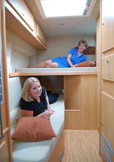 two women are sitting on the bunk beds in a boat