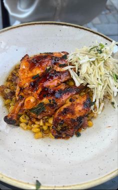 a white plate topped with chicken and corn