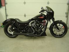 a black motorcycle parked in front of a garage door