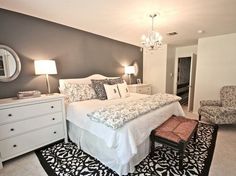 a white bed sitting in a bedroom next to a dresser and chair on top of a rug