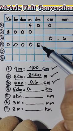 a hand holding a pen over a sheet of paper with numbers and symbols on it