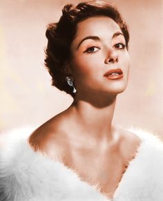 a woman in a white fur coat and earrings