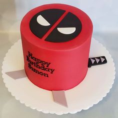 a red cake with a black face on it and a knife sticking out of the top