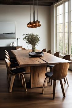 a dining room table with chairs and a vase on the table in front of it