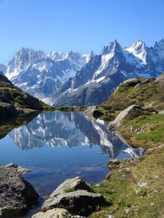 the mountains are reflected in the still water