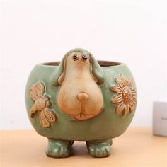 a ceramic animal planter sitting on top of a wooden table