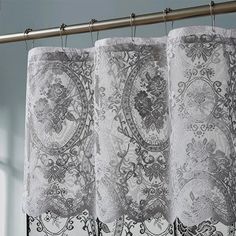 the curtains are hanging in front of the window with an ornate design on them,