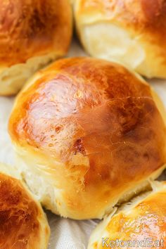 closeup of bread rolls on a white cloth with the top crust removed from it