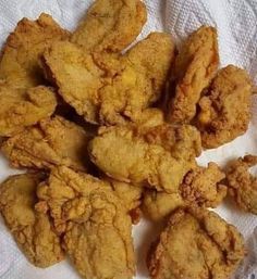 fried chicken pieces are on a white towel