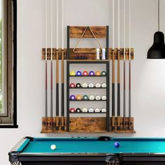 a pool table with cues and balls on it in front of a wall mounted billiard's rack