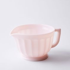 a pink bowl sitting on top of a white table