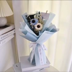 a bouquet of flowers is wrapped in blue paper