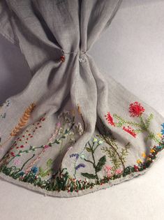 Add a touch of nature to your outfit with this beautiful floral scarf. Hand embroidered with intricate floral designs, this scarf is made of 100% linen and has a lightweight gauze-like texture. Perfect for women who love multifunctional accessories, this rectangle scarf can be worn in a variety of styles. The gray color and embroidered accents make it a perfect addition to any outfit. Dress up a casual look or add a touch of elegance to a formal dress. This scarf is a must-have for any wardrobe. Hand Embroidered Scarf, Bohemian Embroidered Scarves For Spring, Embroidered Bohemian Scarf For Spring, Embroidered Bohemian Scarves For Spring, Bohemian Linen Scarves For Spring, Bohemian Linen Shawl, Scarf Embroidery, Beaded Scarf, Sewing Machine Projects