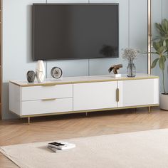 an entertainment center with a flat screen tv mounted on it's sideboard in a living room