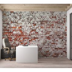 an office area with a brick wall and chair in front of the desk is shown