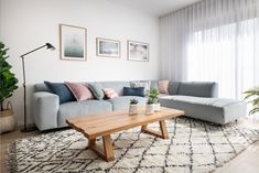 a living room filled with furniture and a wooden coffee table in front of a window