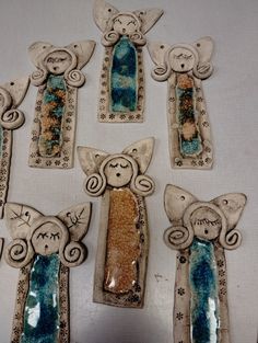 five ceramic angel ornaments are arranged on a table