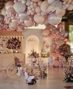 a room filled with lots of balloons and flowers